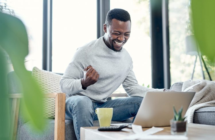 a man sitting on a couch using a laptop